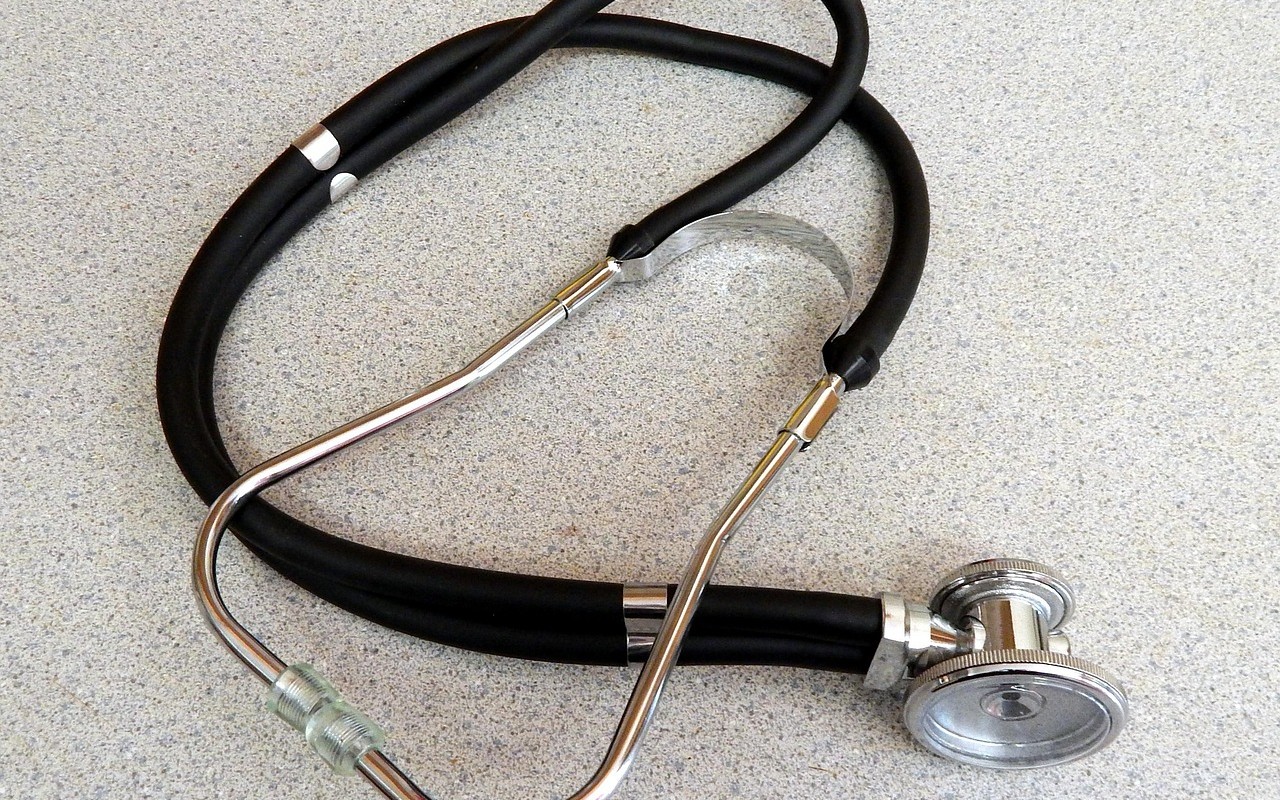 Estetoscopio sobre una superficie gris, símbolo de la consulta médica para diagnosticar la celiaquía