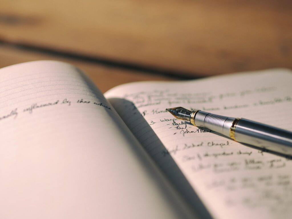 Open notebook with handwritten notes and a fountain pen, used to keep a symptom and food diary