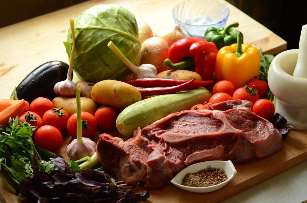 Fresh vegetables and raw meat on a wooden board, naturally gluten-free foods