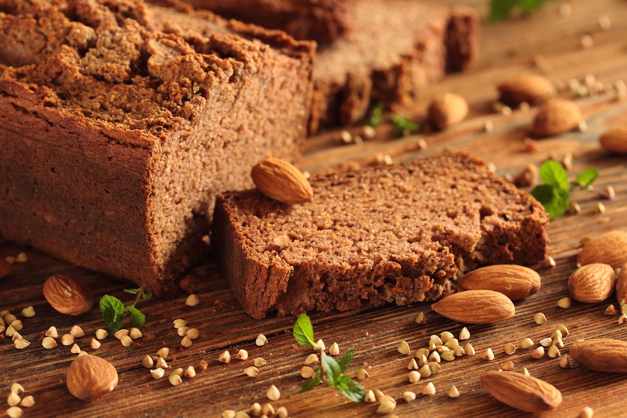 Rebanadas de pan oscuro sin gluten con almendras y granos de trigo sarraceno sobre una mesa de madera