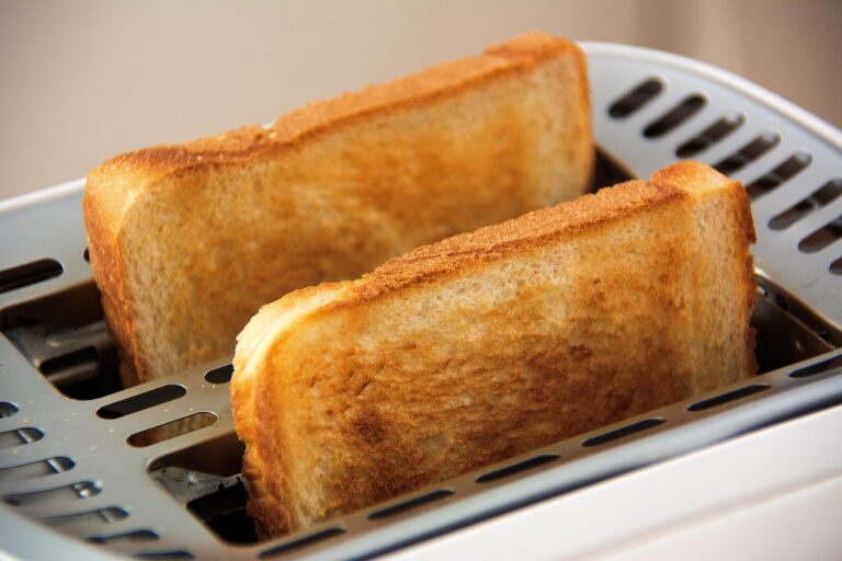 Dos rebanadas de pan tostado en una tostadora, ejemplo de electrodoméstico que puede causar contacto cruzado con gluten