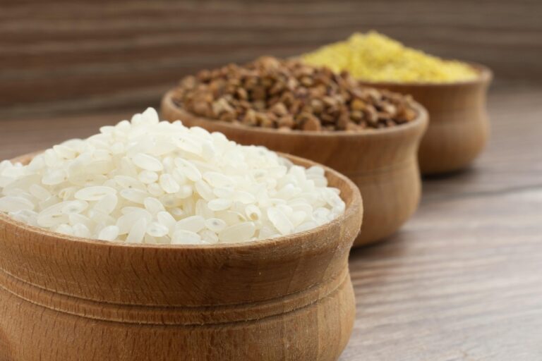 Tres cuencos de madera con arroz blanco, trigo sarraceno y mijo, cereales y pseudocereales sin gluten