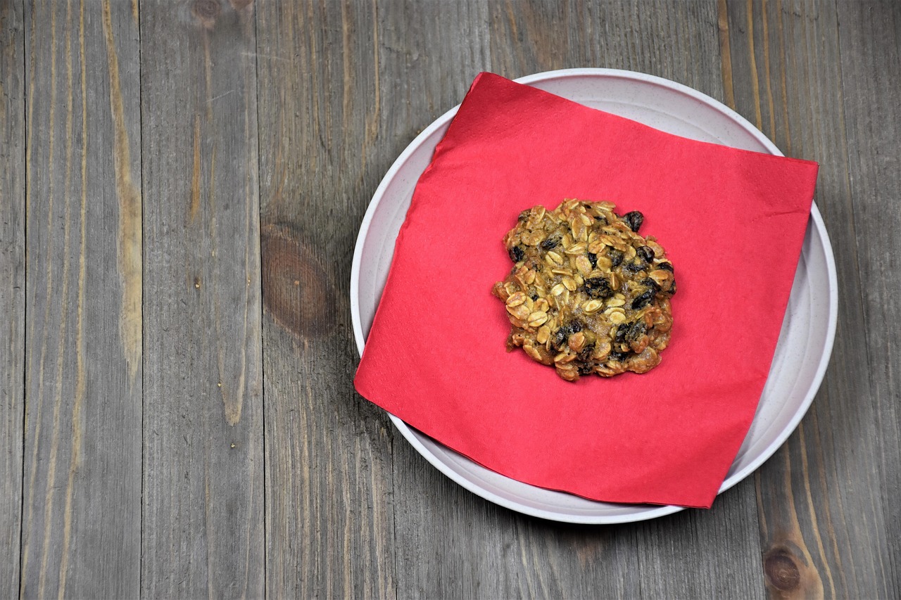 Oat cookie with raisins on a plate and a red napkin
