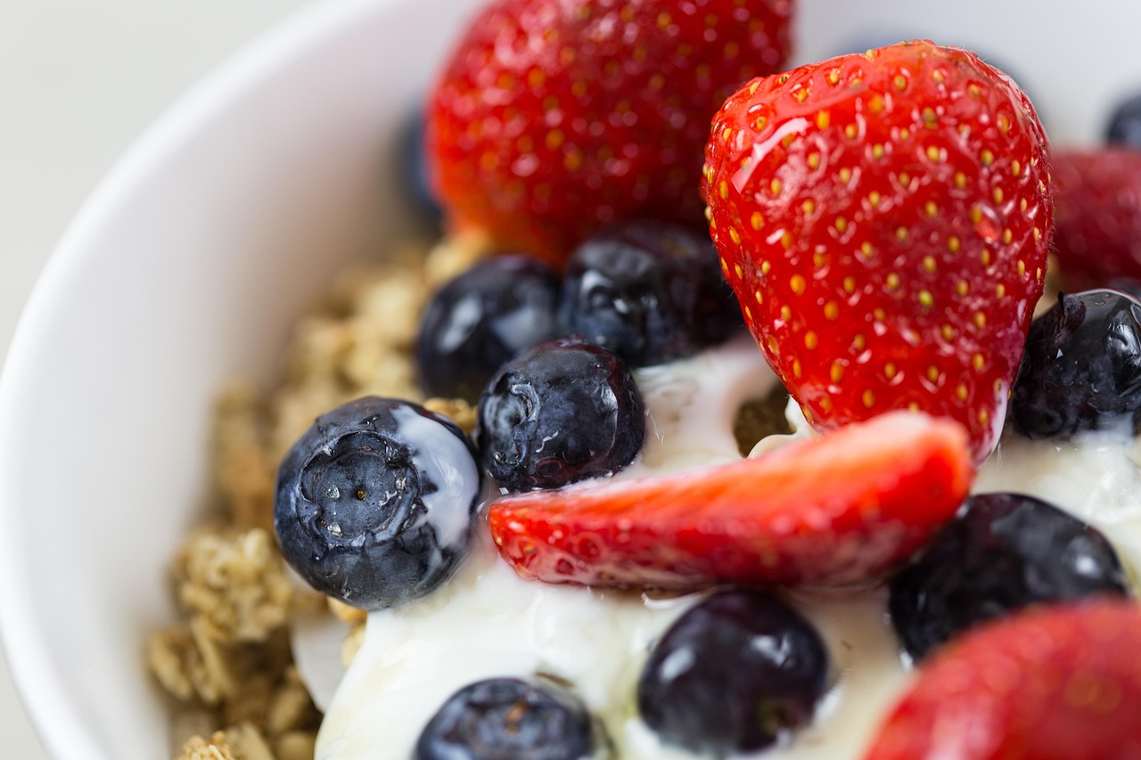 Bowl of yogurt with granola, strawberries and blueberries